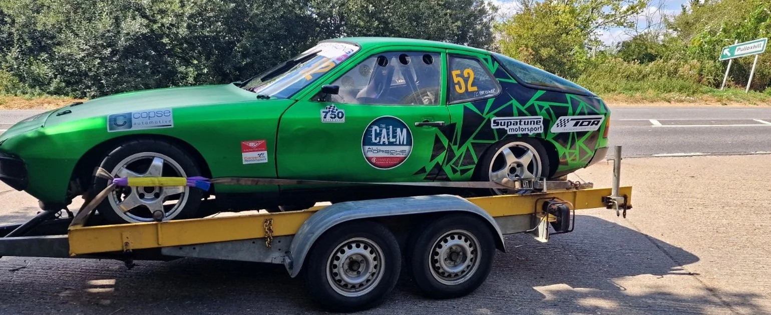 Afiléon Motorsport's historic Porsche 924 race car on its trailer at acquisition, in its previous green livery and number 52